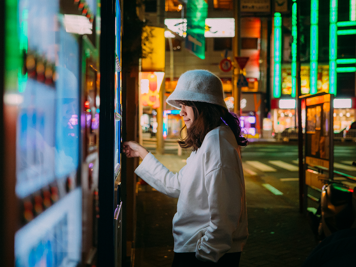 Person paying at a self service terminal on a city street