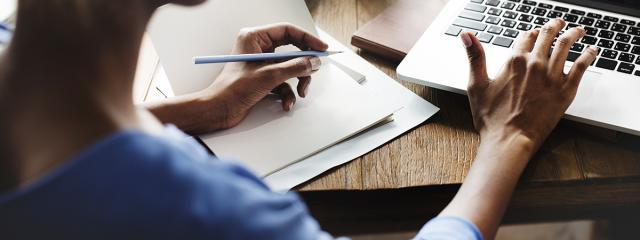Person at computer taking notes