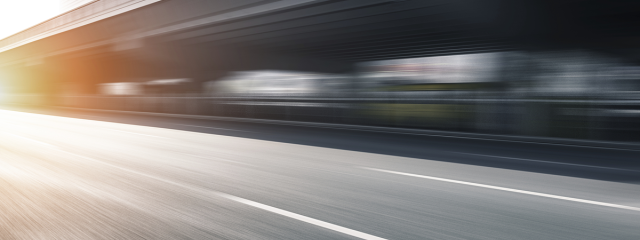 fast moving blur of a roadway with sun coming from the left