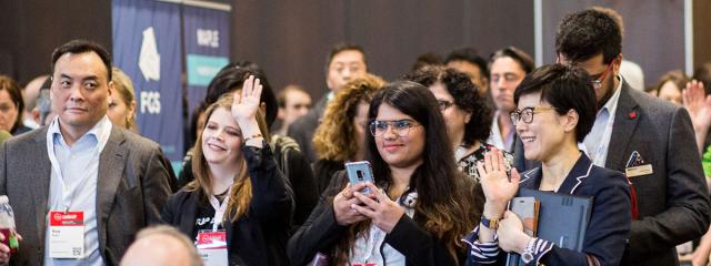 Group of enthusiastic delegates at The SUMMIT watching a presentation