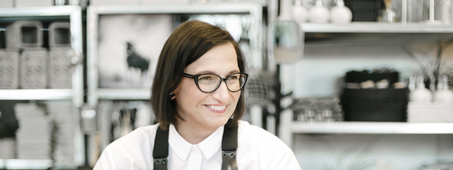 Woman at a computer smiling in a workshop