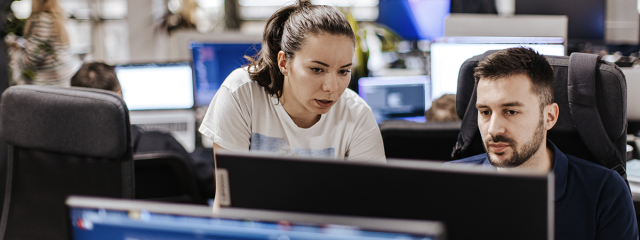 Coworkers looking at computer screen with concern