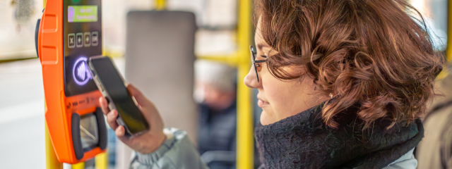 A person using their phone to pay their transit fare
