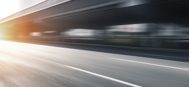 fast moving blur of a roadway with sun coming from the left